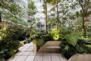 a garden with a bench and plants in a building at QBICo Santa Fe Condominium in Mexico City