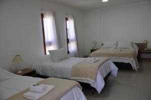 a hotel room with two beds with a laptop on them at Cabañas Casa Blanca in El Mollar