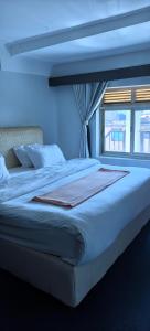 a blue bedroom with a large bed with a window at Kaa Highway Hotel in Mukono