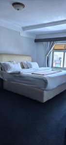a large white bed in a room with a window at Kaa Highway Hotel in Mukono