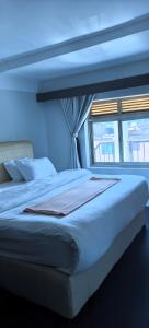 a blue bedroom with a large bed with a window at Kaa Highway Hotel in Mukono +7 photos