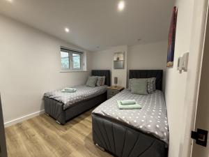 a bedroom with two beds and a window at Crossways Sycamore in Grimsby