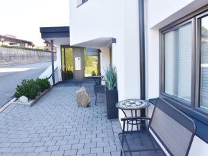 a patio with a bench and a table on a building at Studio mit Lounge in Kirchberg in Tirol +3 photos