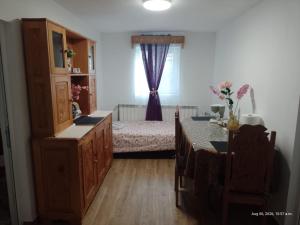 a bedroom with a bed and a table and a window at Casa Narcisa in Călimăneşti