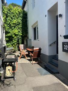 a patio with two chairs and a table in front of a building at Alte Schmiede Karden in Treis-Karden