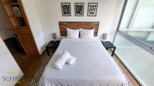 a bedroom with a large white bed with two pillows at QBICo Santa Fe Condominium in Mexico City +20 photos