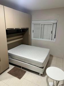 a small bedroom with a bed and a window at Apartamento Unisc in Santa Cruz do Sul +5 photos