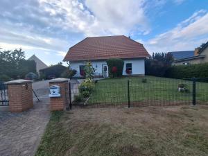 a house with a fence in front of a yard at Dixi-Land in Tauche
