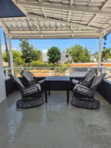 a patio with chairs and a table on a roof at OMY Apartments Nagua 2A in Nagua