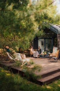 a group of people sitting on a wooden deck at Charszówka in Kobrzyniec Stary