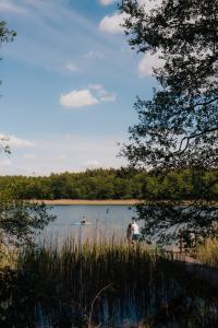 two people standing in the water near a lake at Charszówka in Kobrzyniec Stary