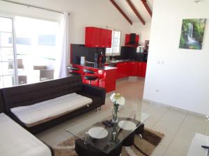 a living room with a black couch and red cabinets at Villa Palulie in Capesterre-Belle-Eau