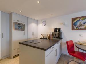 a kitchen with a counter top and a red chair at Studio mit Sauna in Kirchberg in Tirol