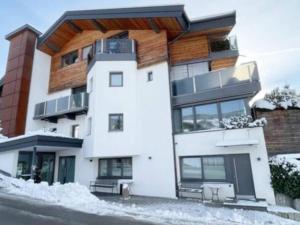 a large white building with snow on the ground at Studio mit Sauna in Kirchberg in Tirol