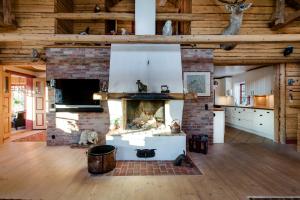 a living room with a fireplace in a wooden building at Ulkeröds Gård in Hedekas