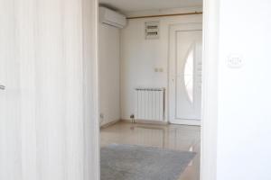 a white room with a door and a rug at Cherry Apartments in Sarajevo