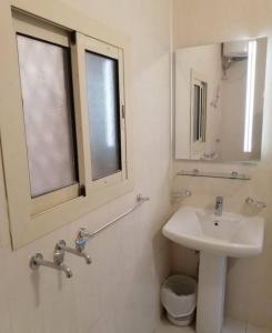 a white bathroom with a sink and a window at دار الباحة فرع رقم 2 in Al Baha