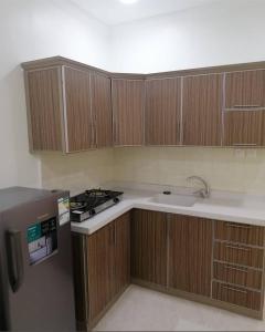 a kitchen with wooden cabinets and a sink and a stove at دار الباحة فرع رقم 2 in Al Baha +9 photos