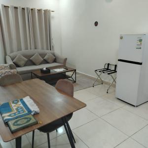 a living room with a table and a refrigerator at دار الباحة فرع رقم 2 in Al Baha