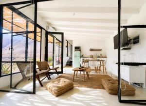 a living room with glass walls and a dining room at Glaciar de Roca Lofts in Horcon