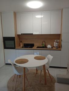 a kitchen with a white table and two chairs at Studio apartman Topolovec in Krapina
