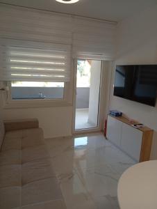 a living room with a large window and a television at Studio apartman Topolovec in Krapina