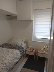 a small bedroom with a bed and a sink at Studio apartman Topolovec in Krapina