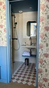 a bathroom with a sink and a shower with a mirror at Hotel Saint-Enogat in Dinard +17 photos