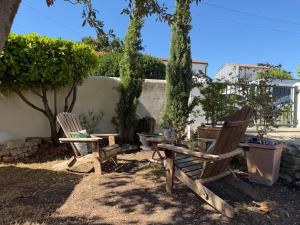 two chairs and a table in a yard with trees at Tredd in La Rochelle