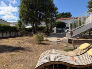 a wooden bench sitting in a yard next to a staircase at Tredd in La Rochelle