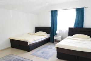 two twin beds in a room with blue curtains at Cherry Apartments in Sarajevo +16 photos