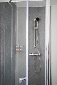 a shower in a bathroom with a glass door at Homesly Guest Rooms, Comfortable En-suite Guest Rooms with Free Parking and Self Check-in in Berwick-Upon-Tweed
