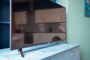 a flat screen tv sitting on top of a cabinet at Homesly Guest Rooms, Comfortable En-suite Guest Rooms with Free Parking and Self Check-in in Berwick-Upon-Tweed