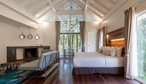 a bedroom with a large bed and a fireplace at Sutera Sanctuary Lodges At Kinabalu Park in Kampong Kundassan