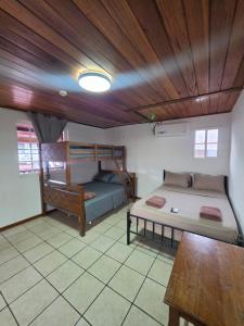 a room with two beds and a wooden ceiling at Casa solarte bocas del toro in Bluff BEach