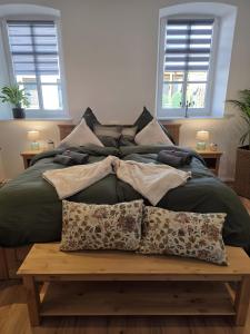 a bedroom with a bed with pillows and a table at Rosenzauber Seeromantik "Kramer" in Weißenstadt