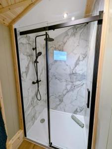 a shower in a room with a marble wall at West Wood Yurts Ltd in Newcastle upon Tyne +92 photos