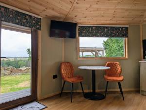 a tiny house with a table and two chairs at West Wood Yurts Ltd in Newcastle upon Tyne