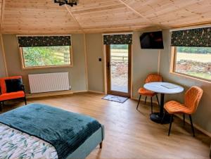 a bedroom with a bed and a table and chairs at West Wood Yurts Ltd in Newcastle upon Tyne