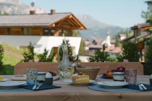 a table with food and a glass vase on it at Planat in San Cassiano