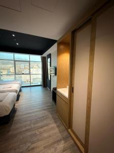 a hotel room with beds and a large window at فندق قصر الكادي in An Nikāshah