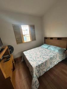 a small bedroom with a bed and a window at Casa da Conceição in Capitólio