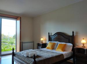 a bedroom with a bed with two lamps and a window at Single House in Vila Real