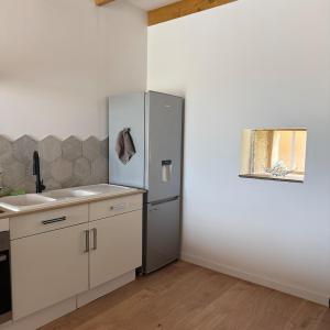 a kitchen with a refrigerator and a sink at Maison de Campagne 