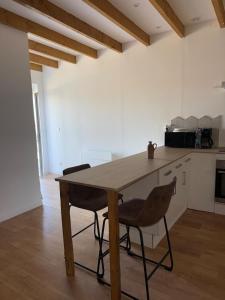 a kitchen with a wooden table and two chairs at Maison de Campagne 