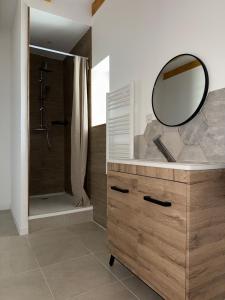 a bathroom with a shower and a mirror on a dresser at Maison de Campagne 