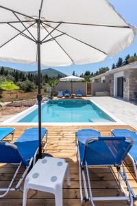 a pool with two chairs and an umbrella at Tsoutsis Villas in Marantochori