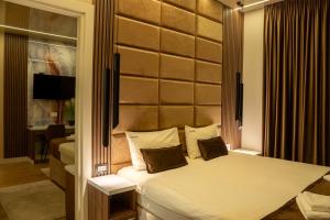 a bedroom with a large bed in a room at Hotel Eterna Hill Rooftop in Sajmište