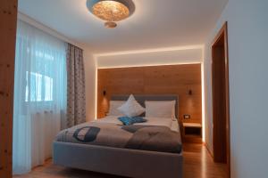 a bedroom with a bed and a large window at Planat in San Cassiano