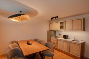 a kitchen with a table and chairs and a kitchen with a sink at Planat in San Cassiano +51 photos